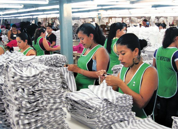 ASSEMBLY LINE: Workers at INT Trading check T-shirts made for the Disney label.
