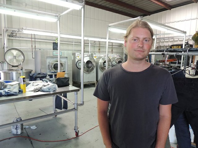 WASH ALTERNATIVE: Lukus Eichmann, founder of Tortoise, at Eco Prk laundry. Eichmann said the laundry offers a different way to give jeans a stylish look, one that doesn’t use chemicals deemed harmful.