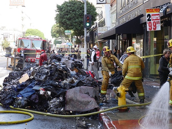 Fire fighters extinguish the fire on Dec. 4 at the Italian Fashions by Suzie store, located on the ground floor of the 824 Building on Los Angeles Street in downtown L.A. 