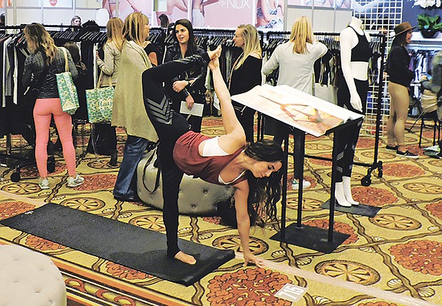 A yogi strikes a post at the Alo Yoga booth at Active Collective in Huntington Beach, Calif. The trade show was held concurrently with its sister show, Swim Collective.