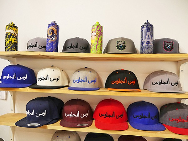 Raised in Los Angeles-brand caps with Arabic script spelling out the words "Los Angeles"