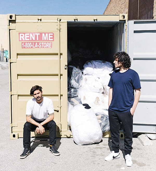 Models wear Upcycle while standing in front of a scrap-filled shipping container | Photo by Bobby Escobedo