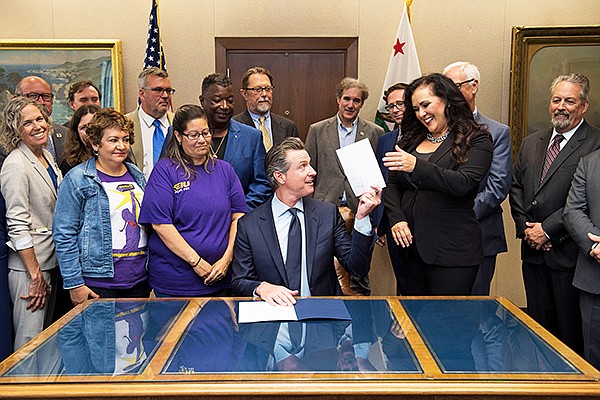 California Governor Gavin Newsom signs AB 5 on Sept 18.