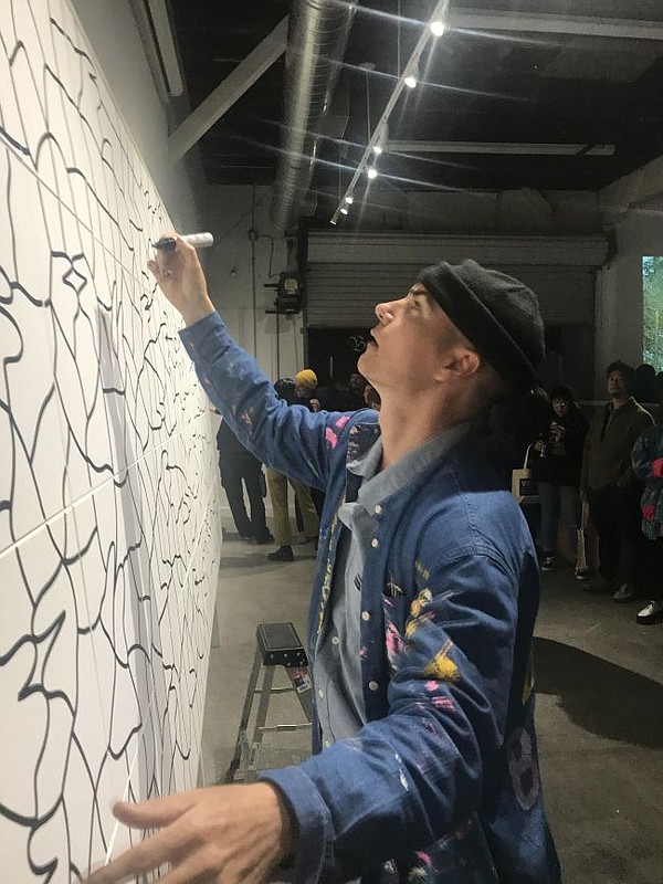Lucas Beaufort does a live painting of a mural at a March 12 release party for his collection with Brixton.