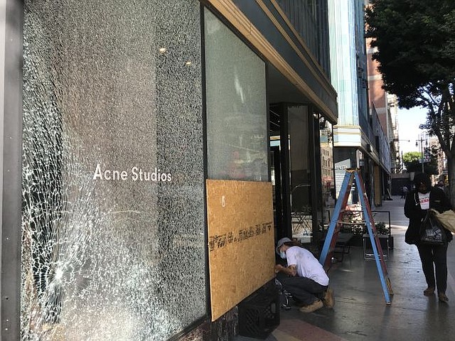 A clean-up effort takes place outside of Acne Studios in downtown Los Angeles on the morning of Oct. 28, after looting that followed the Los Angeles Dodgers' World Series victory on the night of Oct. 27.