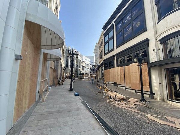 Workers boarding up the 2 Rodeo retail street in Beverly Hills, Calif. Photo: Patrik Simpson