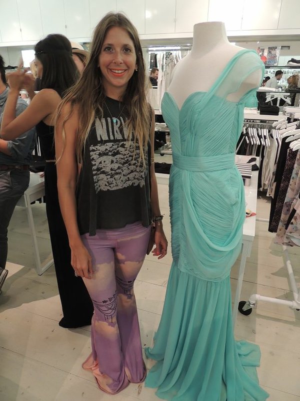 Lindsay Hemric of Teeki stands beside a mannequin displaying a look from the Red Carpet Green Dress label.