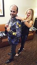 Julie Dreyfus, sales rep for Tallia Orange Clothing, helping Kia Shadi with Olympic & Downtown Men’s Collection try on a Tallia evening jacket.