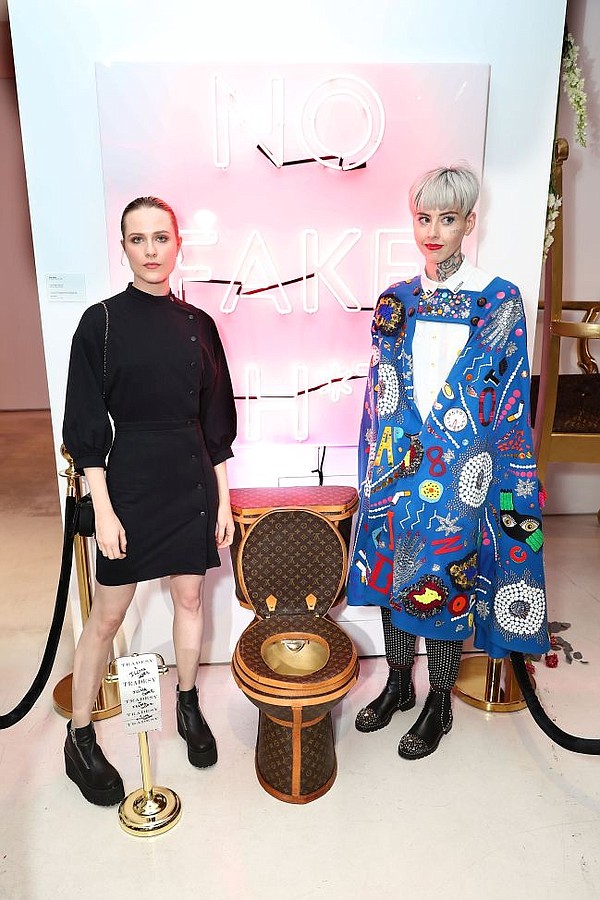 Westworld's Evan Rachel Wood, left, and artist Illma Gore pose by a Louis Vuitton toilet seat crafted by Gore. Photo by Joe Scarnici/Getty Images for Tradesy.