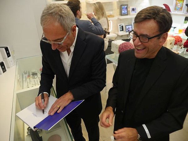 Ron Robinson, left, signs a copy of Years for Ronnie Schneider. Schneider is the author of Out of Our Heads. It's his memoir of touring with The Rolling Stones and working with The Beatles in the 1960s.